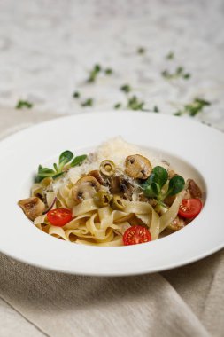 Açık arkaplanda kiraz domatesli deniz ürünleri makarnası.