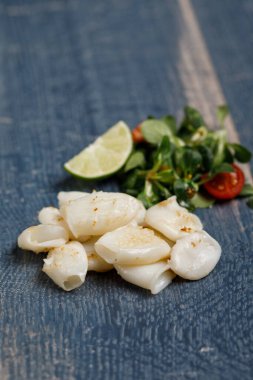 mavi ahşap arka planda limonlu kalamar