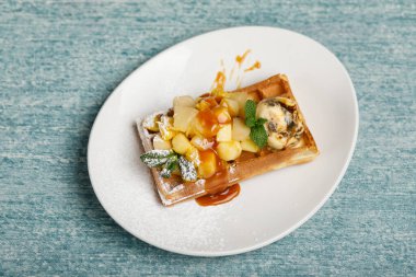 Ananaslı tatlı waffle ve beyaz tabakta nane.