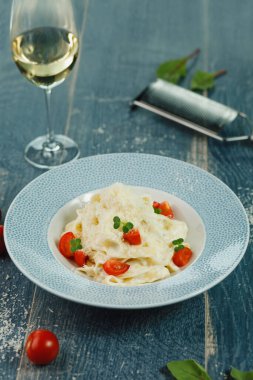 Mavi ahşap arka planda parmesanlı domatesli makarna