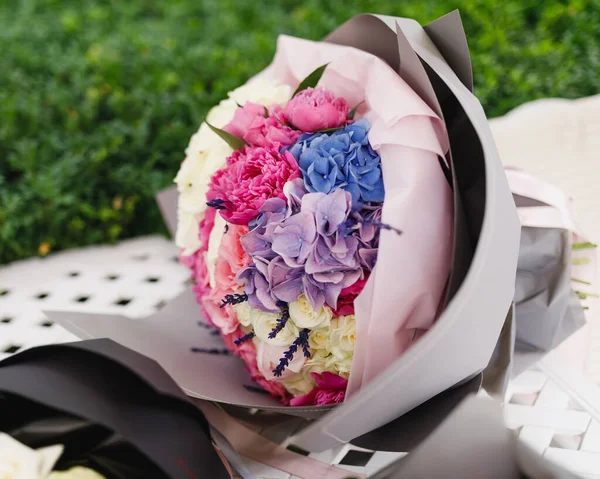 bouquet of different flowers in paper packaging