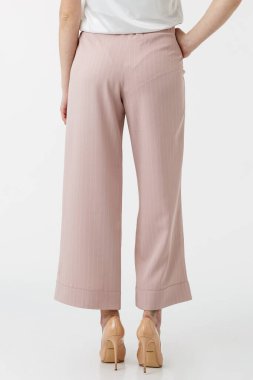 Beyaz arka planda gül pantolonlu genç kız