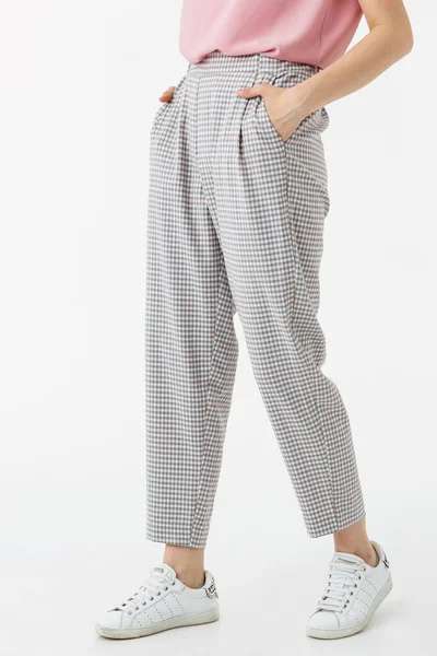 Beyaz arka planda gri pantolonlu genç kız.