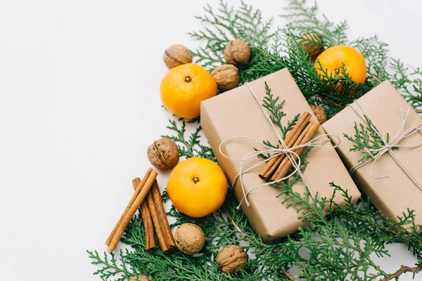 Toned instagram image wrapping rustic eco Christmas gifts with craft paper, string, tangerines and natural cypress branches on white background — Stock Photo, Image