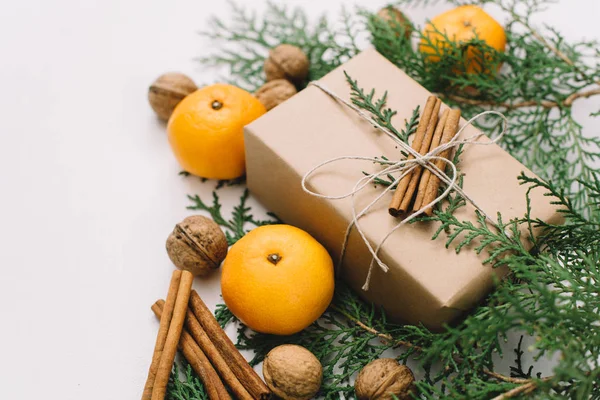 Toned instagram image wrapping rustic eco Christmas gifts with craft paper, string, tangerines and natural fir branches on white background — Stock Photo, Image