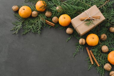 Mandalina kutuları çam ile yılbaşı yeni yıl kompozisyon siyah arka plan tatil dekorasyon tonda yeşillik konisi