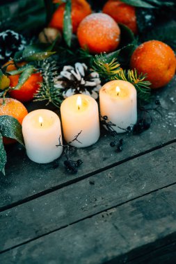 Noel kompozisyon ile mandalina, çam kozalakları, ceviz ve ahşap arka plan, mum tatil dekorasyon