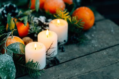 Tonlu görüntü mandalina, çam kozalakları, ceviz ile Noel kompozisyon ve ahşap zemin, tatil dekorasyon üzerine mumlar
