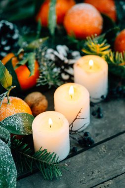 Noel kompozisyon ile mandalina, çam kozalakları, ceviz ve ahşap arka plan, mum tatil dekorasyon