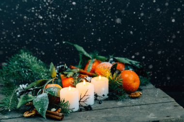Kar tanesi Noel kompozisyon mandalina, çam kozalakları, ceviz ve ahşap zemin, tatil dekorasyon üzerine mum tonlu görüntü