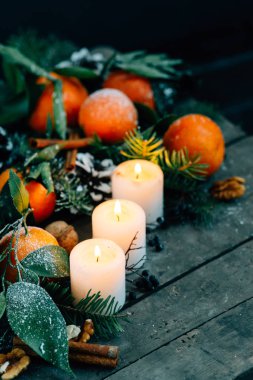 Tonlu görüntü mandalina, çam kozalakları, ceviz ile Noel kompozisyon ve ahşap zemin, tatil dekorasyon üzerine mumlar