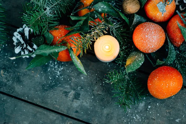 Film bak görüntü mandalina, çam kozalakları, ceviz ile Noel kompozisyon ve ahşap zemin, tatil dekorasyon üzerine mumlar — Stok fotoğraf