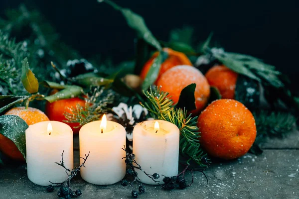 Noel kompozisyon ile mandalina, çam kozalakları, ceviz ve ahşap arka plan, mum tatil dekorasyon — Stok fotoğraf