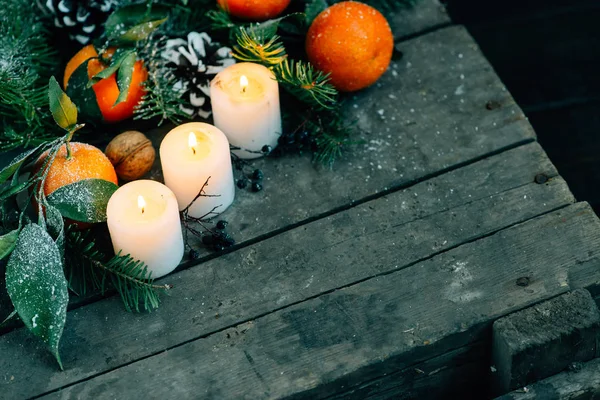 Toned image Christmas composition with Tangerines, Pine cones, Walnuts and Candles on Wooden Background, holiday decoration — Stock Photo, Image