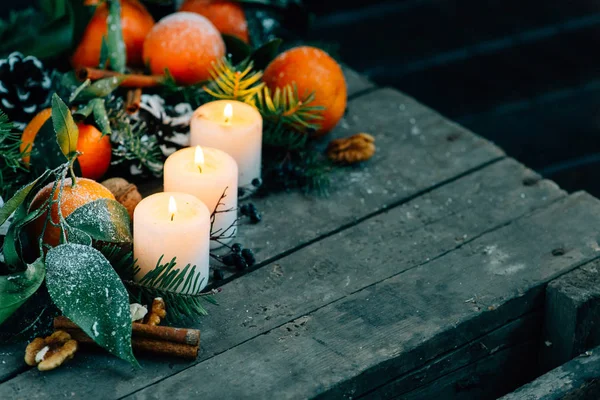 Christmas composition with Tangerines, Pine cones, Walnuts and Candles on Wooden Background, holiday decoration — Stock Photo, Image