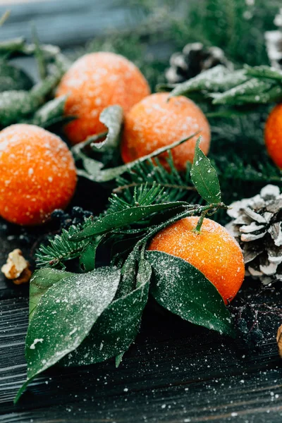 Christmas composition with snowy Tangerines, Pine cones, Walnuts on Wooden Background, holiday decoration — Stock Photo, Image