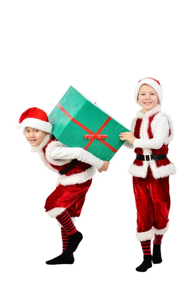 Młodzi chłopcy szczęśliwi w santa ubrania przytrzymanie pudełko świąteczne na plecach. Na białym tle. — Zdjęcie stockowe