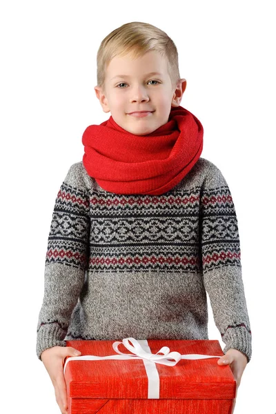 一个可爱的小孩男孩在温暖冬天穿毛衣和白色背景与礼物盒上的红围巾的时尚肖像 — 图库照片