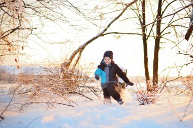 Having oyunculuk ile kar, açık havada kar yağışı sırasında kış giysileri sevimli küçük komik çocuk. Ormandaki etkin boş çocuk. Çocuk şapka, el eldiven