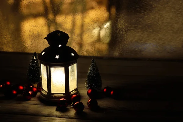 Christmas lantern with snowfall, candles, view from the window on the night street — Stock Photo, Image