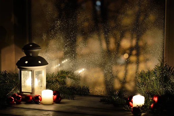 Christmas lantern with snowfall, candles, view from the window on the night street — Stock Photo, Image