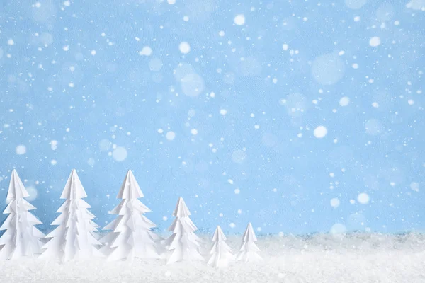 Winter Christmas minimalist background with white paper trees on blue drawing snowflakes