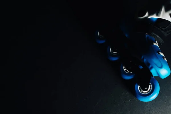 Vista de cerca de patines de patines azules en línea o patinaje sobre fondos grunge teñidos oscuros —  Fotos de Stock