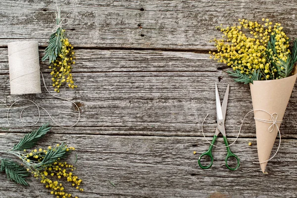 Faça um buquê de mimosa. ataduras cordéis e tesouras na mesa de madeira rústica — Fotografia de Stock