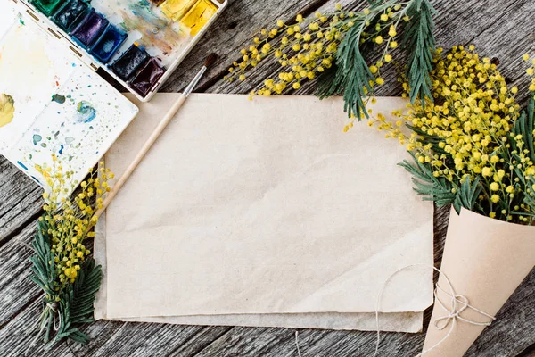 Buquê de mimosa. ataduras fio e tesoura sobre mesa de madeira rústica, papel velho para texto e aquarelas — Fotografia de Stock