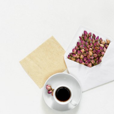 Zarf ve çay beyaz arka planda, düz metin için boş kart ile mor kuru gül yatıyordu, havai görünümü,