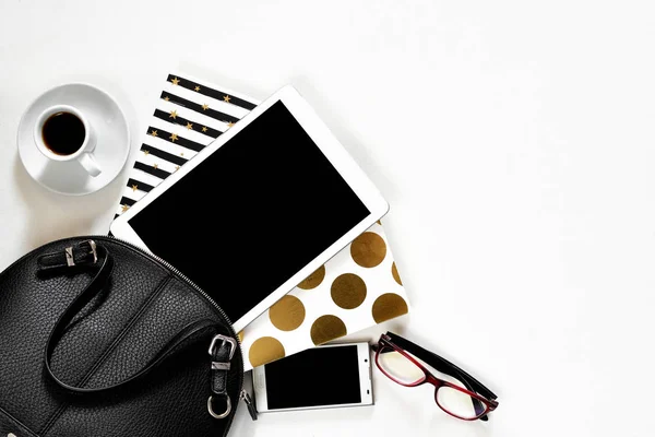 Womens office desk on white background touch pad tablet gadget cellphone with gold stylish books black handbag, top view — Stock Photo, Image