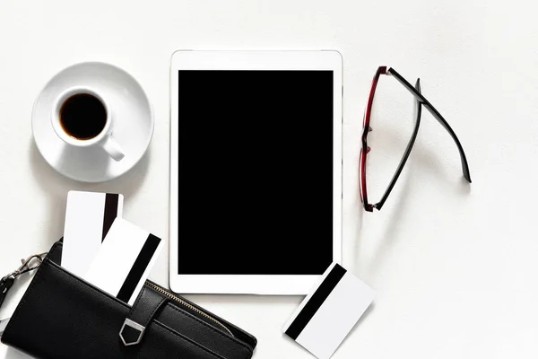 Escritorio de oficina para mujer en una tableta de almohadilla táctil de fondo blanco con libros de oro elegantes tarjetas de crédito billetera negro, vista superior — Foto de Stock