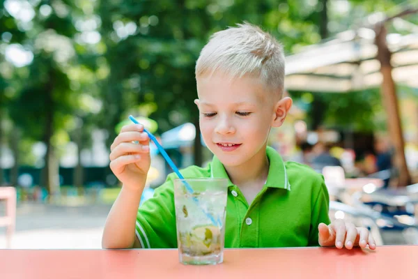 Lindo niño rubio en la cafetería bebiendo mojito cóctel — Foto de Stock