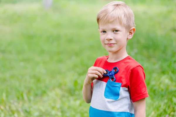 Teen pojke spelar en fidget spinner utomhus — Stockfoto