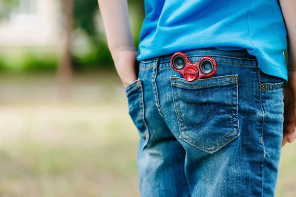 Zbliżenie fidget pokrętła w tylnej kieszeni spodni jeans zewnątrz — Zdjęcie stockowe