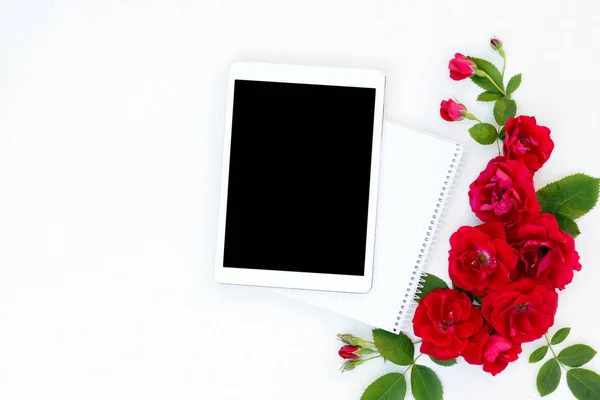 Плоска квіткова рамка з планшетними, червоними та бежевими квітковими бруньками на білому тлі . — стокове фото