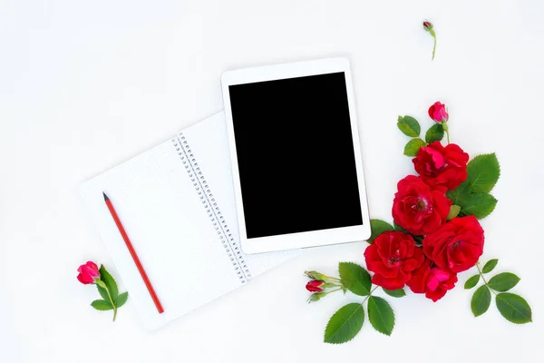Плоска квіткова рамка з планшетними, червоними та бежевими квітковими бруньками на білому тлі . — стокове фото