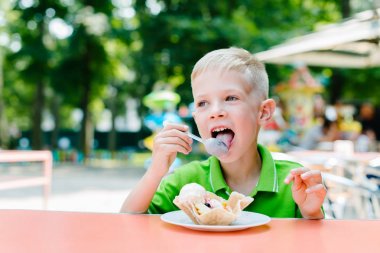 Mutlu sevimli komik çocuk kafede dondurma yiyor