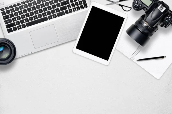 Beyaz ofis fotoğraf resepsiyon masası dizüstü bilgisayar, tablet, kamera ve cam. Kopya alanı ile Üstten Görünüm