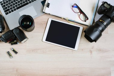 Bilgisayar, tablet, sarf malzemeleri ve kamera ile fotoğraf ofis resepsiyon masası. Kopya alanı ile Üstten Görünüm