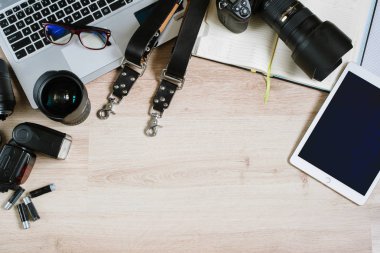 Bilgisayar, tablet, sarf malzemeleri ve kamera ile fotoğraf ofis resepsiyon masası. Kopya alanı ile Üstten Görünüm
