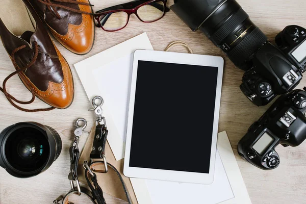 Fotografie hipster werktafel ingesteld met tablet, film, vintage schoenen, lenzen, leveringen en digitale film camera's. Bovenaanzicht met kopie ruimte — Stockfoto