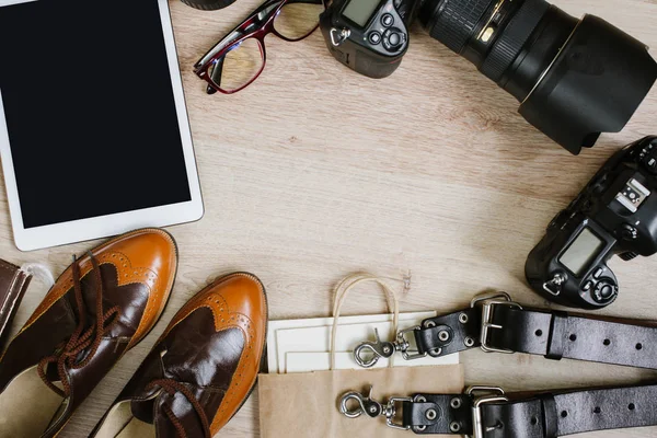 Fotografie hipster werktafel ingesteld met tablet, film, vintage schoenen, lenzen, leveringen en digitale film camera's. Bovenaanzicht met kopie ruimte — Stockfoto