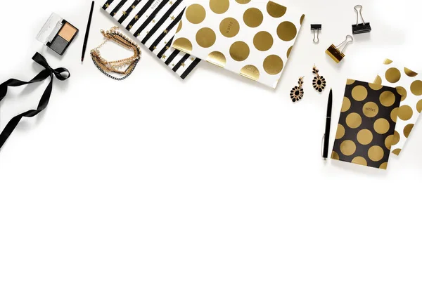 Düz yatıyordu moda kadınsı ev ofis çalışma alanı ile telefon, fincan kahve, şık siyah altın notebook, kozmetik ve beyaz arka plan üzerinde takı. Kadın iş çalışma masası üzerinde Üstten Görünüm