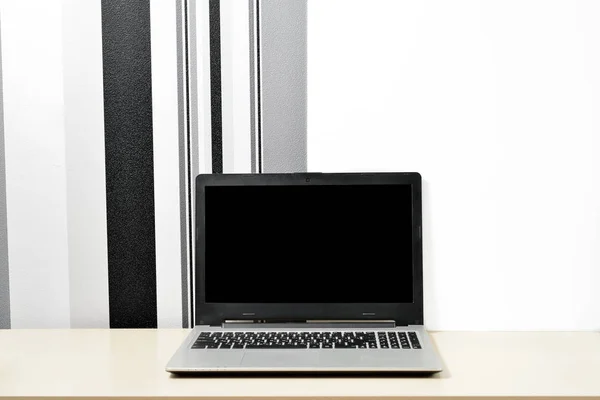 Håna upp laptop, anteckningsboken på skrivbord på det minimalistiska svartvit fondvägg — Stockfoto