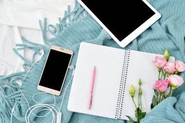Düz yatıyordu tablet, telefon, fincan kahve ve beyaz battaniye ile turkuaz ekose çiçekler