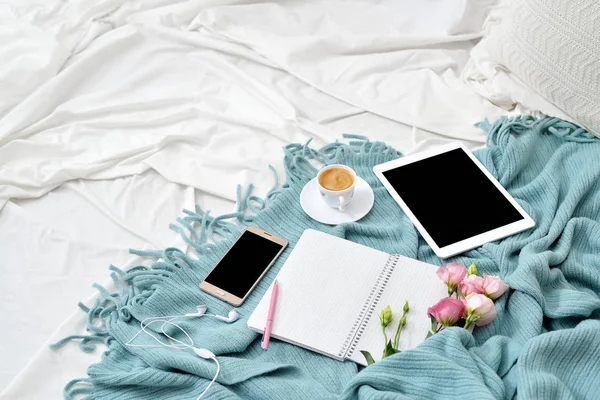 Tableta plana, teléfono, taza de café y flores en manta blanca con cuadros de color turquesa —  Fotos de Stock