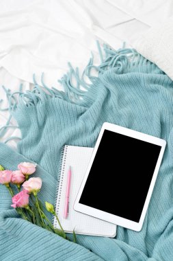 Düz yatıyordu tablet, telefon, fincan kahve ve beyaz battaniye ile turkuaz ekose çiçekler