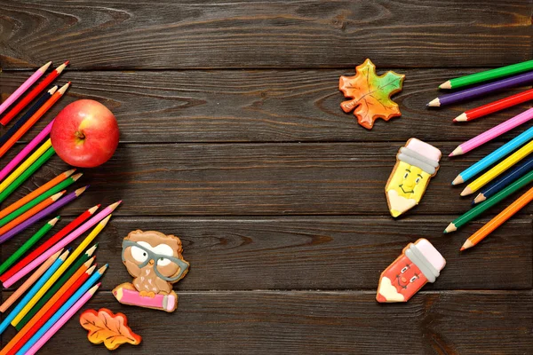 Geri okul kavramı ve arka plan için renkli kalemler, kırmızı appple gingerbread ahşap tablo