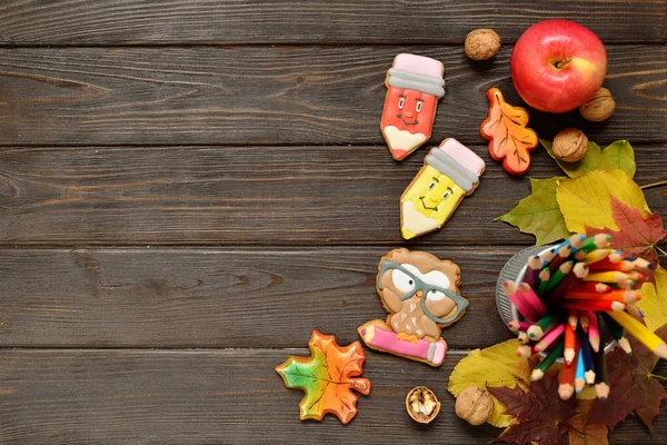 Geri okul kavramı ve arka plan için renkli kalemler, kırmızı appple gingerbread ahşap tablo